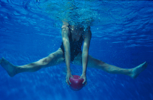 Aquatraining, Aquatherapie bei Margot Zeitvogel-Schönthier, Massagewirkung Waden beim Grätschsprung mit roten Ball nach unten drücken